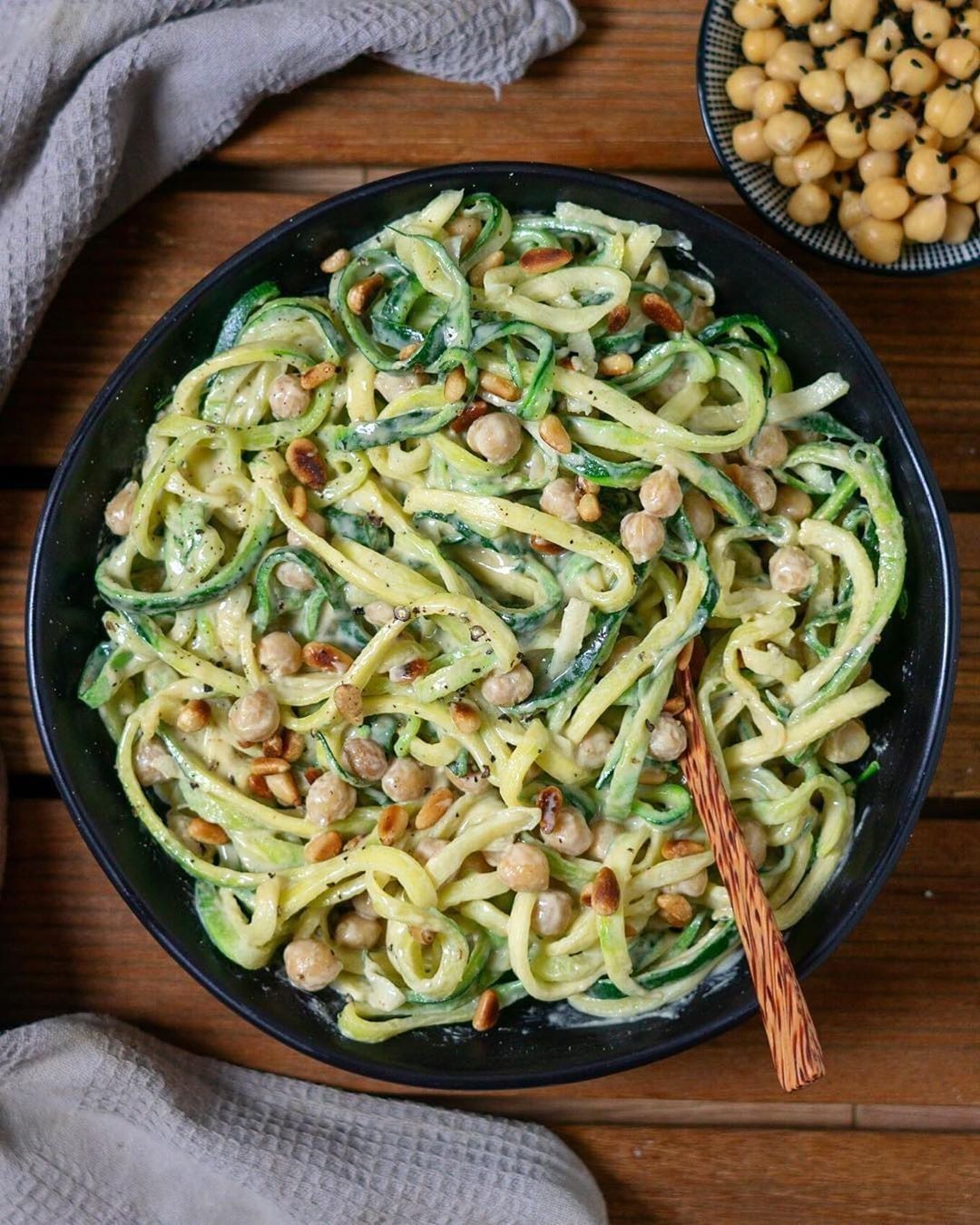 creamy tahini-garlic sauce with zucchini noodles, chickpeas and pine nuts